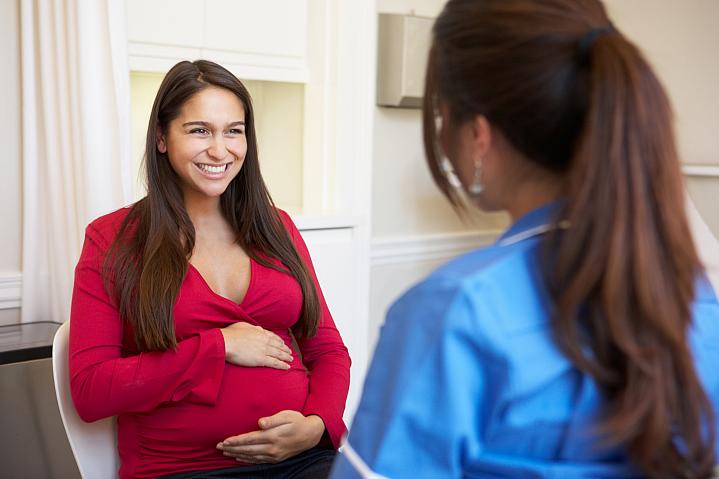Pregnant woman talking with health care professional