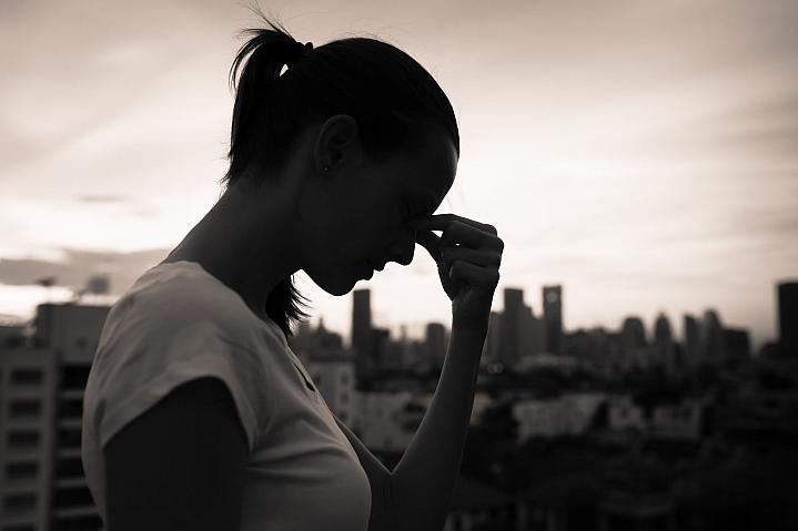 Silhouette of a woman resting her head in her hands Silhouette of a woman resting her head in her hands