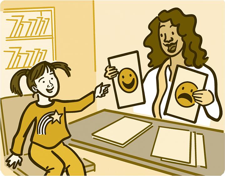 An adult showing a child flashcards with pictures of different faces An adult showing a child flashcards with pictures of different faces