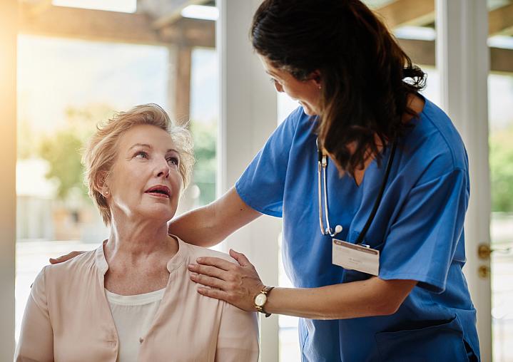 Health care provider smiling while talking to an older adult Health care provider smiling while talking to an older adult