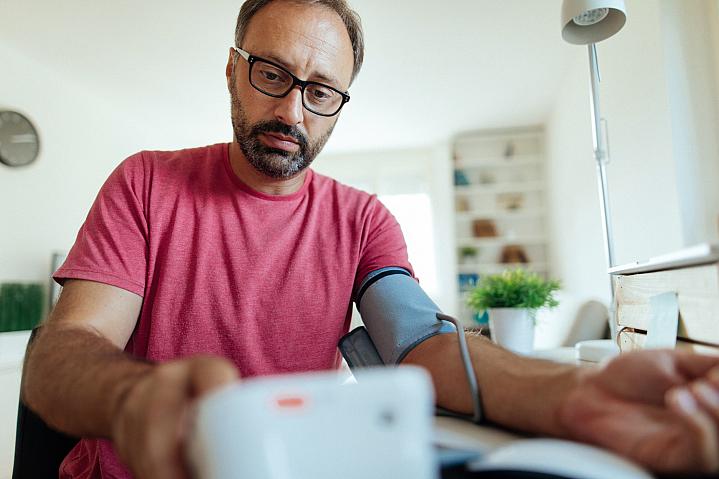 Man checking his blood pressure at home Man checking his blood pressure at home