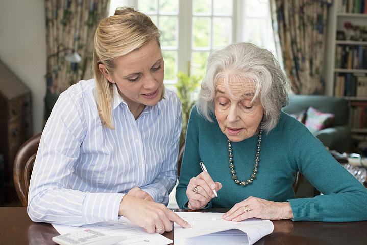 Woman helping older adult with paperwork