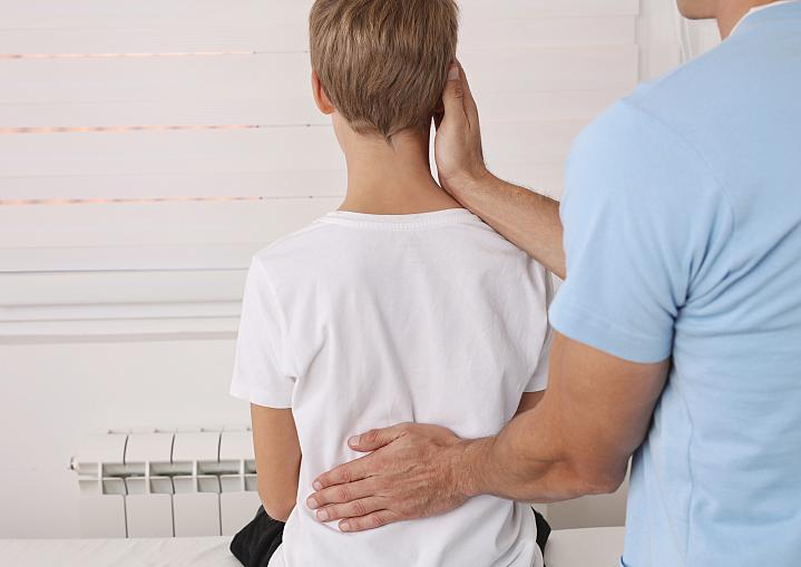 Child getting his back examined by a health care professional Child getting his back examined by a health care professional