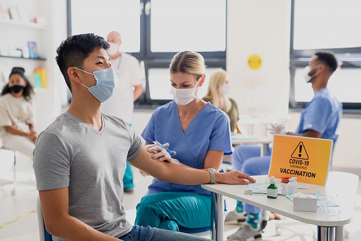Man with facemask getting vaccinated at a clinic Man with facemask getting vaccinated at a clinic