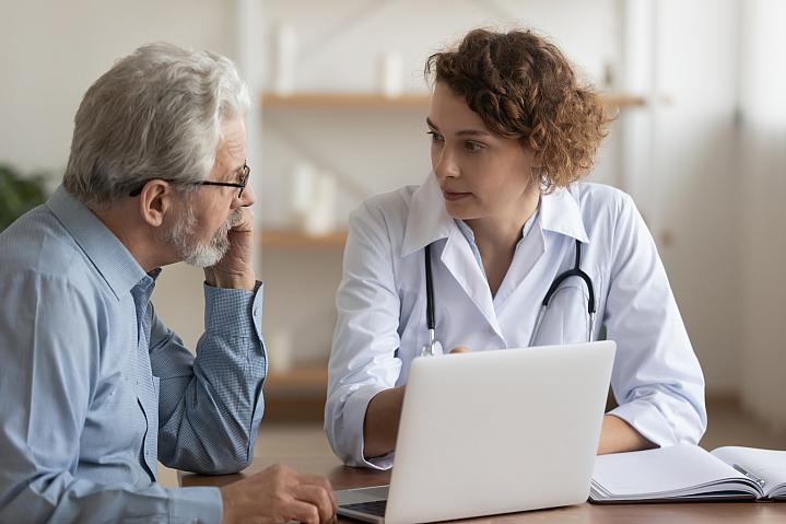 Female doctor talking with older male patient