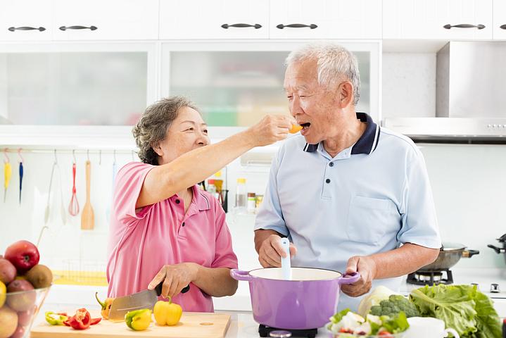 Senior couple cooking vegetables Senior couple cooking vegetables