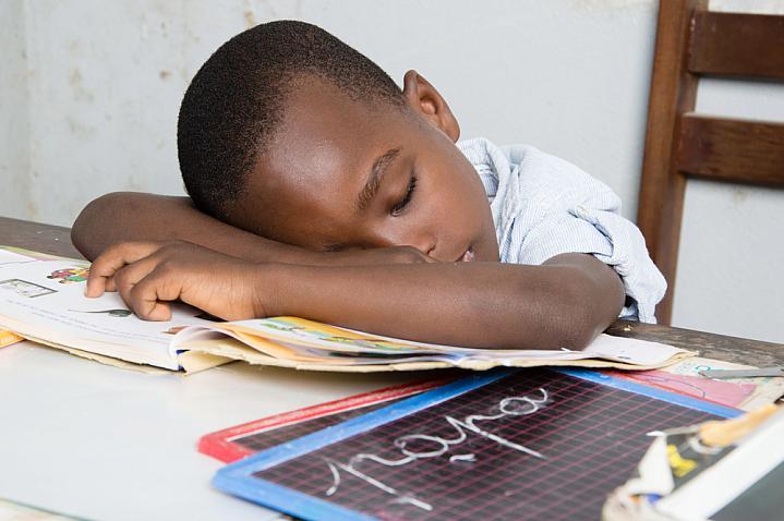 Boy asleep on his desk with his head on a book Boy asleep on his desk with his head on a book