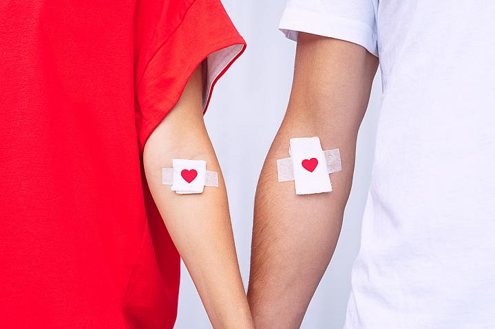 Blood donors showing their bandages with hearts on them, after blood donation Blood donors showing their bandages with hearts on them, after blood donation.
