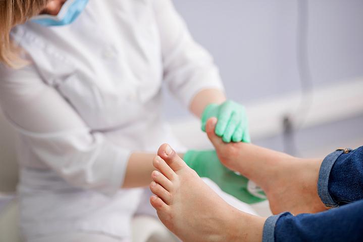 A doctor examining a patient's foot.