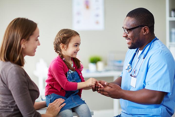 A young child and her mom talking with a doctor in the clinic A young child and her mom talking with a doctor in the clinic.